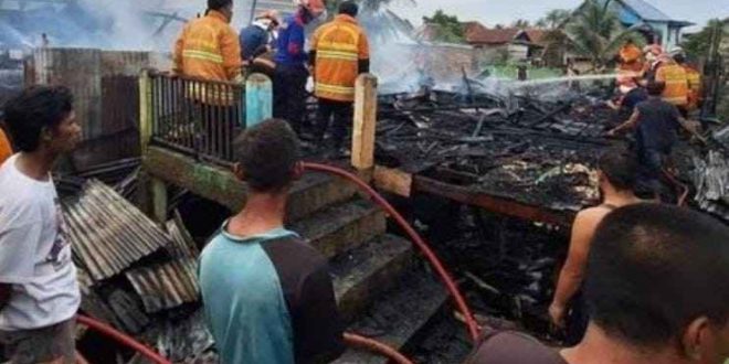 Warga dan petugas memadamkan sisa api yang melahap dua rumah di 35 Ilir Palembang, Senin (2/12/2024). Foto: Sumselheadline/Ela.