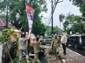 Sejumlah petugas melepas APK yang masih terpasang di sejumlah titik Kota Palembang, Jumat (13/12/2024). Foto: Kominfo Palembang.