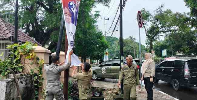 Sejumlah petugas melepas APK yang masih terpasang di sejumlah titik Kota Palembang, Jumat (13/12/2024). Foto: Kominfo Palembang.