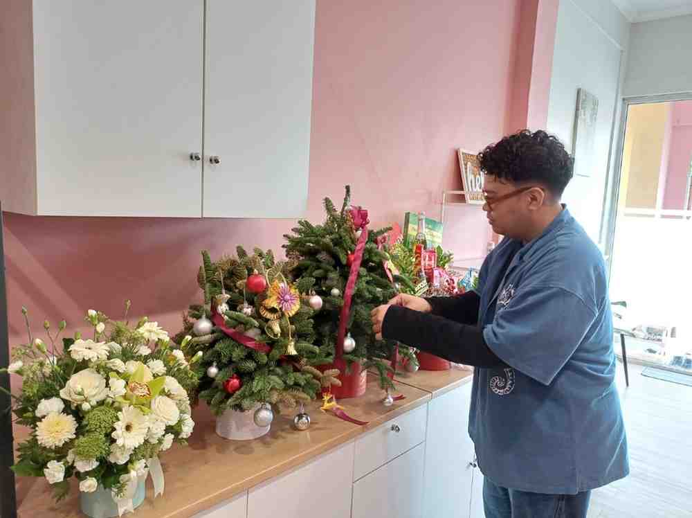 Manager Hello Florist Palembang Eki Pratama menyusun kembang pernik natal. Foto: Sumselheadline/Pitria.
