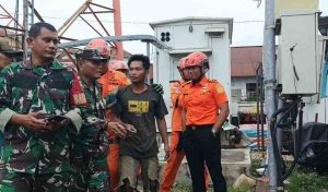 Aswandi (28), tengah, akhirnya turun dari tower komunikasi, setelah dirayu petugas, Senin (9/12/2024). Foto: Sumselheadline/Ela.