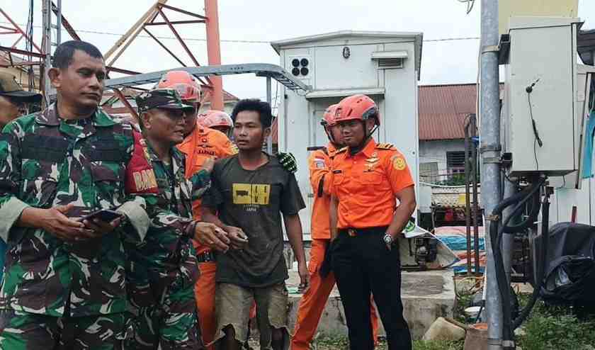 Aswandi (28), tengah, akhirnya turun dari tower komunikasi, setelah dirayu petugas, Senin (9/12/2024). Foto: Sumselheadline/Ela.