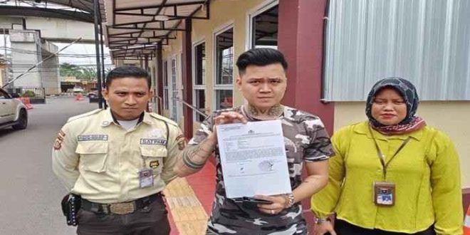 Jemmy, menunjukkan bukti laporan terhadap babysister yang dituduh menganiaya anaknya. Foto: tribunsumsel.com.
