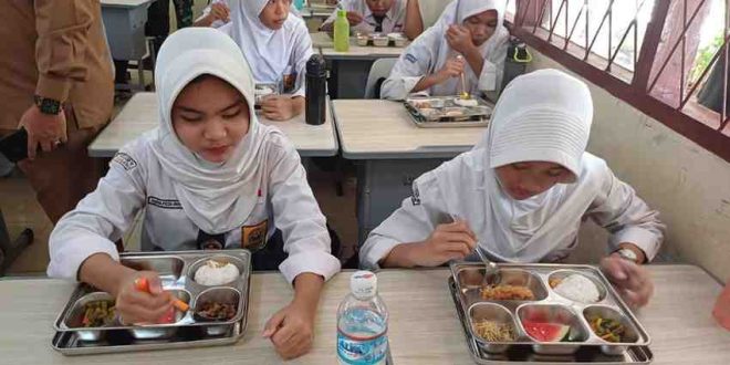 Siswa kelas IX SMP Negeri 40 Palembang menikmati menu MBG, Senin (13/1/2025). Foto: Sumselheadline/Pitria.