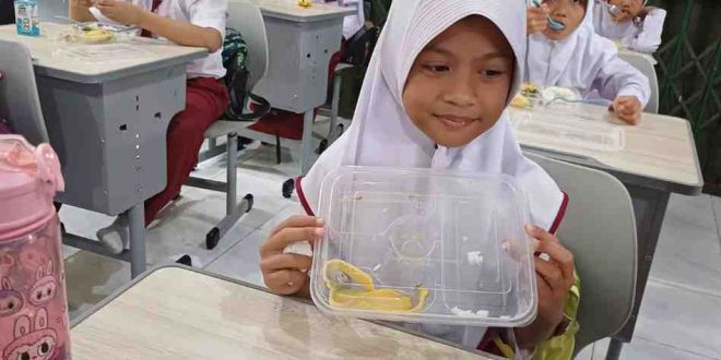 Queenza Elena, murid SDN 25 Palembang, yang menikmati makanan bergizi gratis, Senin (6/1/2025). Foto: Sumselheadline/Pitria.