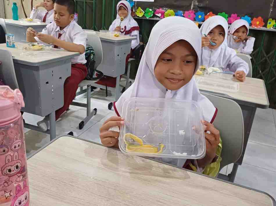 Queenza Elena, murid SDN 25 Palembang, yang menikmati makanan bergizi gratis, Senin (6/1/2025). Foto: Sumselheadline/Pitria.
