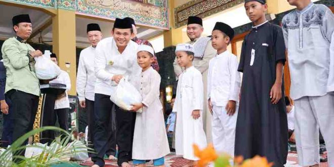 Pj Walikota Palembang, Cheka Virgowansyah memberikan bingkisan kepada anak yatim di Masjid Daruussaid, Palembang, Kamis (30/1/2025). Foto: Kominfo Palembang.