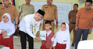 Kepala Dinas Pendidikan Kota Palembang, Adrianus Amri membagikan buku Ramadan di SDN 129 Palembang, Selasa (25/2/2025). Foto: Kominfo Palembang.