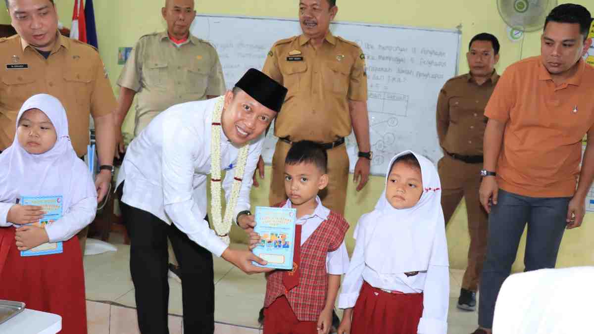 Kepala Dinas Pendidikan Kota Palembang, Adrianus Amri membagikan buku Ramadan di SDN 129 Palembang, Selasa (25/2/2025). Foto: Kominfo Palembang.