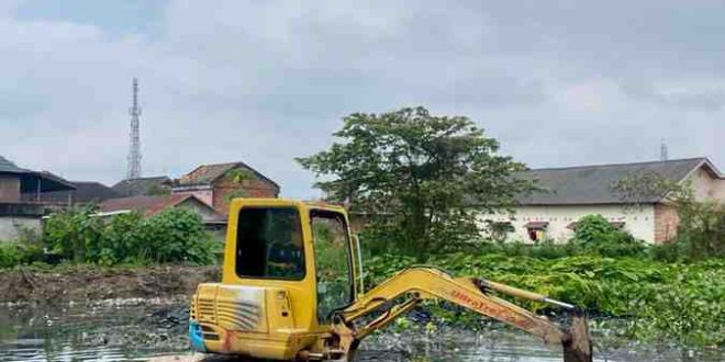 Alat berat yang melakukan pengerukan kolam retensi di kawasan MIN Palembang. Foto: Kominfo Palembang.
