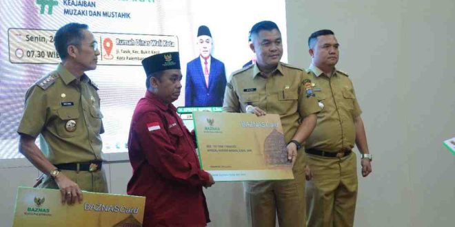 Ketua BAznas Palembang, Kgs Muhammad Ridwan Nawawi secara simbol,is menerima zakat Ramadan dari Walikota Palembang Ratu Dewa dan Sekda Palembang, Senin (24/3/2025). Foto: Sumselheadline/Pitria.