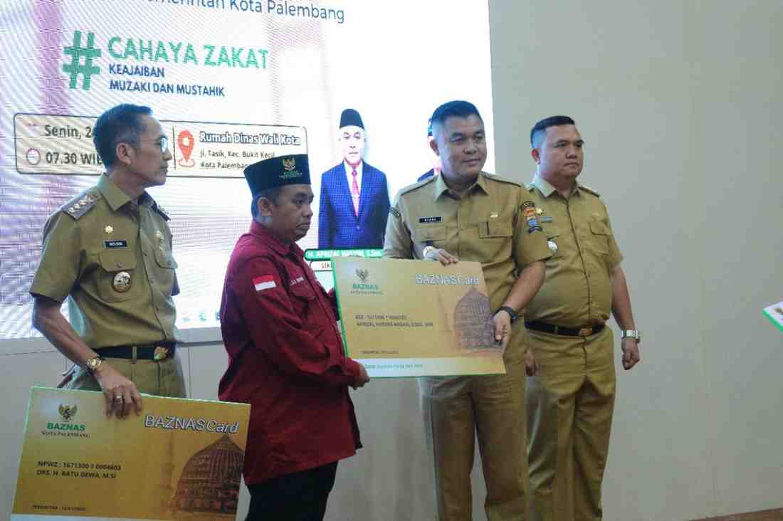 Ketua BAznas Palembang, Kgs Muhammad Ridwan Nawawi secara simbol,is menerima zakat Ramadan dari Walikota Palembang Ratu Dewa dan Sekda Palembang, Senin (24/3/2025). Foto: Sumselheadline/Pitria.