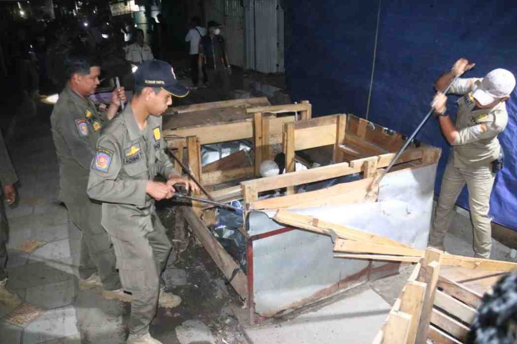 Petugas gabungan membongkar lapak-lapak pedagang yang berada di saluran air dan trotoar di kawasan Pasar 16 Ilir Palembang, Selasa (29/4/2025) malam. Foto: Kominfo Palembang.