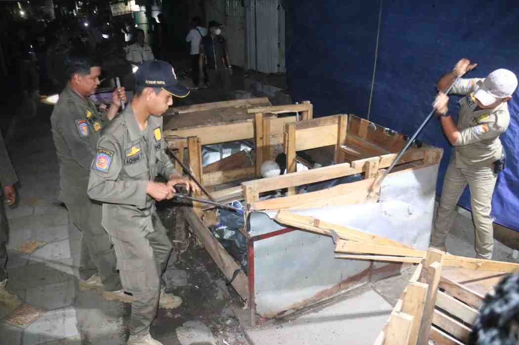 Petugas gabungan membongkar lapak-lapak pedagang yang berada di saluran air dan trotoar di kawasan Pasar 16 Ilir Palembang, Selasa (29/4/2025) malam. Foto: Kominfo Palembang.