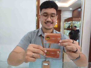 Pegawai Galeri 24 Pegadaian Palembang, di Kompleks Palembang Square (PS) Mall memperlihatkan dinar yang mulai dilirik warga untuk investasi, Rabu (23/4/2025). Foto: Sumselheadline/Pitria.