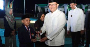 Sekda Sumsel Edward Candra menyerahkan tropi kepada salah satu juara pada penutupan STQH Sumsel di Talangubi, PALI, Minggu (27/4/2025) malam. Foto: Humas Pemprov Sumsel.