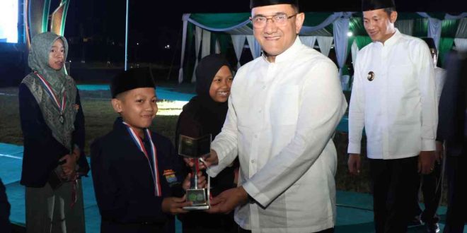 Sekda Sumsel Edward Candra menyerahkan tropi kepada salah satu juara pada penutupan STQH Sumsel di Talangubi, PALI, Minggu (27/4/2025) malam. Foto: Humas Pemprov Sumsel.