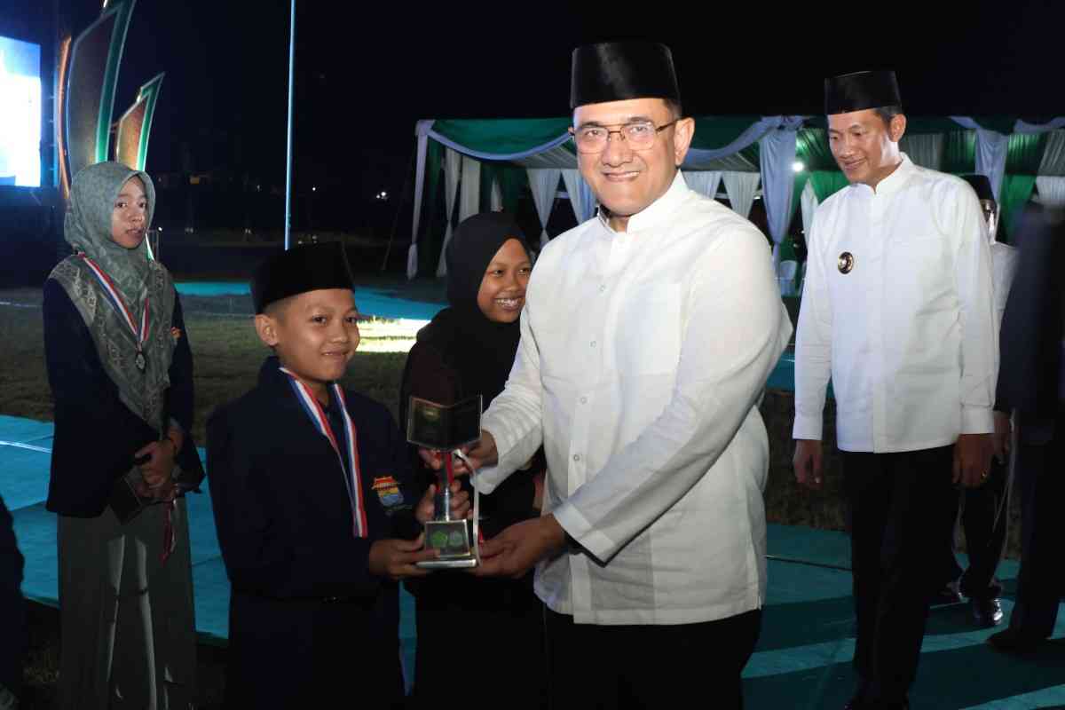 Sekda Sumsel Edward Candra menyerahkan tropi kepada salah satu juara pada penutupan STQH Sumsel di Talangubi, PALI, Minggu (27/4/2025) malam. Foto: Humas Pemprov Sumsel.