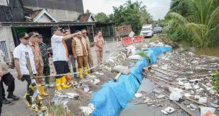 Bupati Muba, HM Toha dan jajaran meninjau banjir yang meluap nyaris menggenangi jalan raya. Foto: Dok Kominfo Muba.