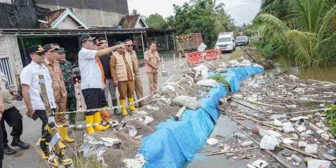 Bupati Muba, HM Toha dan jajaran meninjau banjir yang meluap nyaris menggenangi jalan raya. Foto: Dok Kominfo Muba.