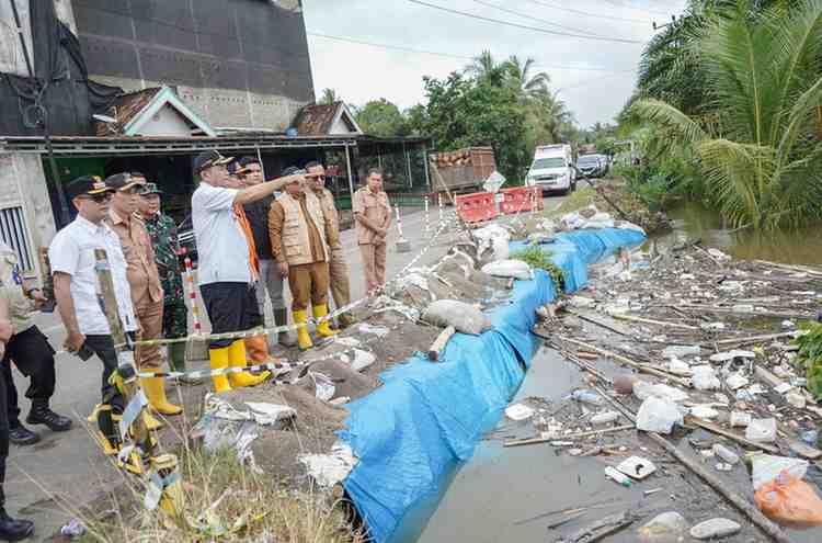 Bupati Muba, HM Toha dan jajaran meninjau banjir yang meluap nyaris menggenangi jalan raya. Foto: Dok Kominfo Muba.