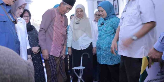 Ramlan mencoba alat bantu kakai pasca kecelakaan. Foto: Kominfo Palembang.