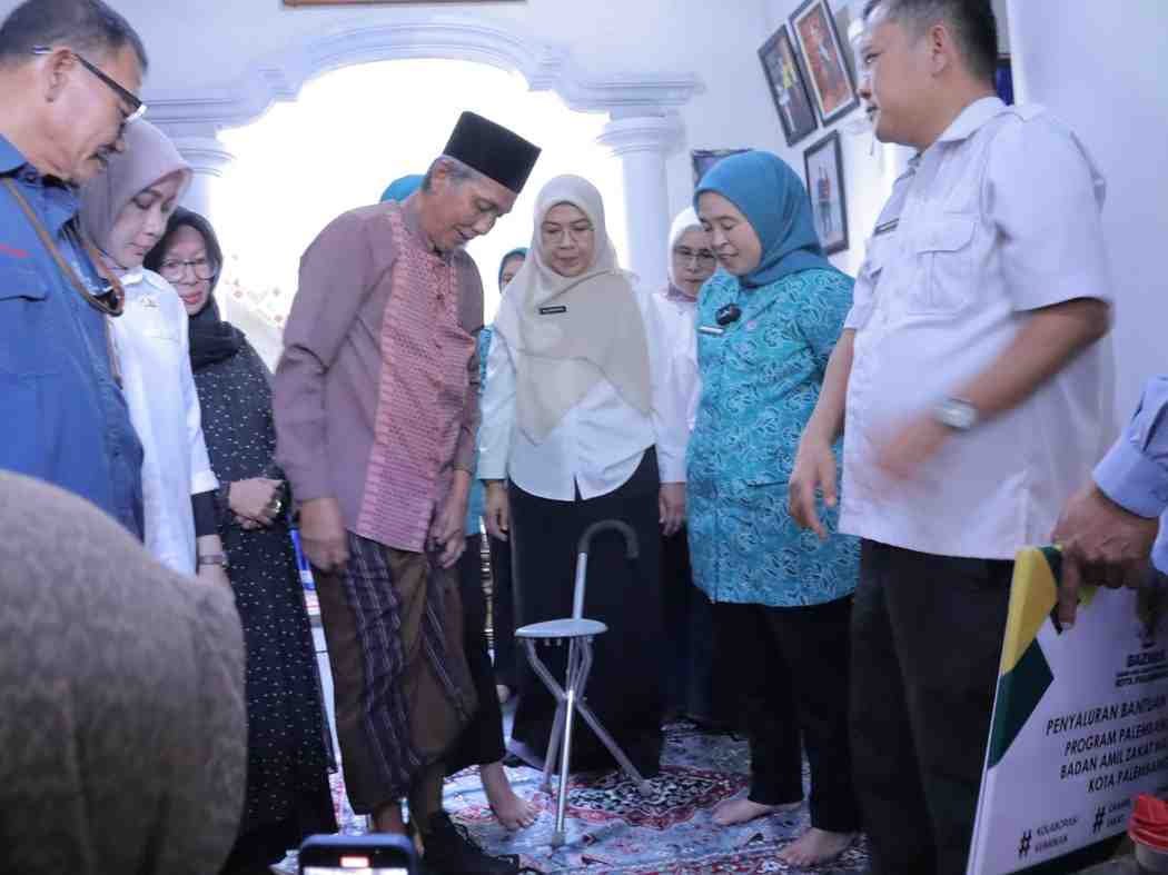 Ramlan mencoba alat bantu kakai pasca kecelakaan. Foto: Kominfo Palembang.