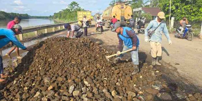 Warga bersama aparat Kecamatan Babat Toman, bersama-sama memperbaiki jalan berlubang di DCesa Sugiraya. Foto: Dok Camat Babat Toman.