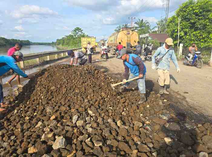 Warga bersama aparat Kecamatan Babat Toman, bersama-sama memperbaiki jalan berlubang di DCesa Sugiraya. Foto: Dok Camat Babat Toman.