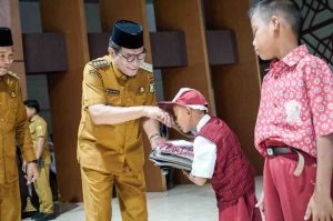 Bupati Muba, HM Toha secara simbolis menyerahkan seragam dan tas gratis kepada para siswa di Muba, Selasa (6/5/2025). Foto: Kominfo Muba.