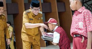 Bupati Muba, HM Toha secara simbolis menyerahkan seragam dan tas gratis kepada para siswa di Muba, Selasa (6/5/2025). Foto: Kominfo Muba.