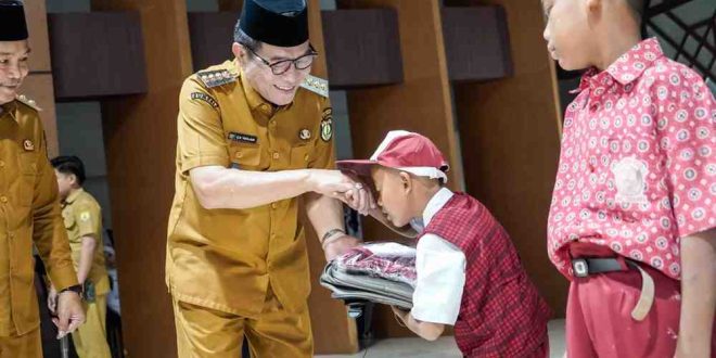 Bupati Muba, HM Toha secara simbolis menyerahkan seragam dan tas gratis kepada para siswa di Muba, Selasa (6/5/2025). Foto: Kominfo Muba.