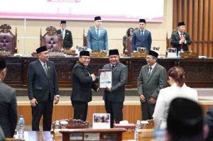 Direktur Jenderal Pemeriksaan Keuangan Negara I BPK RI, Sarjono menyerahkan hasil pemeriksaan keuangan daerah TA 2024 kepada Gubernur Sumsel, Herman Deru pada Paripurna XIV DPRD Provinsi Sumsel di Ruang Rapat Paripurna DPRD Sumsel, Rabu (4/6/2025). Foto: Humas Pemprov Sumsel.
