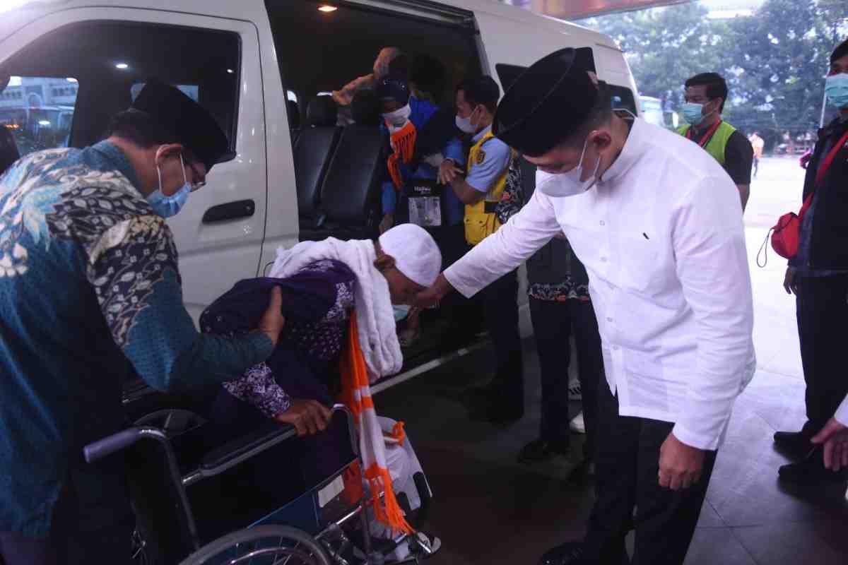 Sekda Sumsel, Edward Candra menyalami salah seorang jemaah risti asal Kloter 1 OKU Timur, Jumat (13/6/2025). Foto: Humas Pemprov Sumsel.