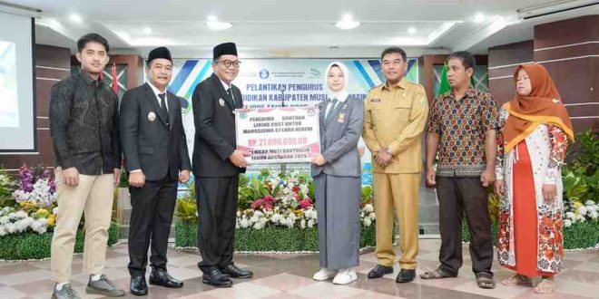 Bupati Muba, HM Toha secara simbolis menyerahkan bantuan living cost pada Rini, mahasiswa asal Muba yang akan kuliah di Belanda, Senin (2/6/2025). Foto: Kominfo Muba.