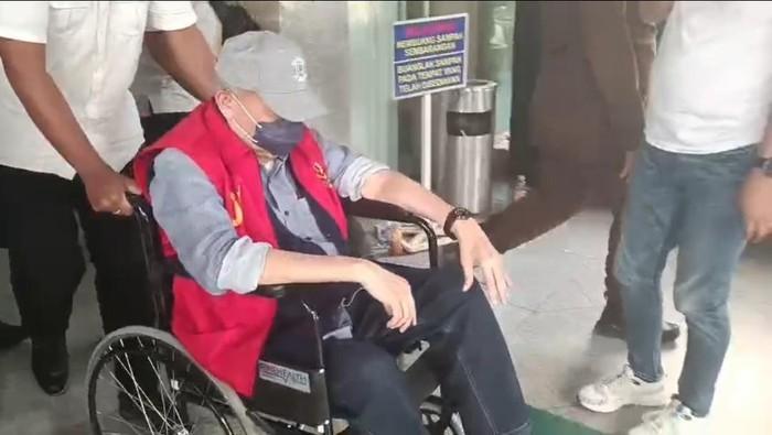 Alex Noerdin saat dinawa menggunakan kursi roda di Kejati Sumsel, Rabu (23/7/2025). Foto: IST/Dok Detik.com.