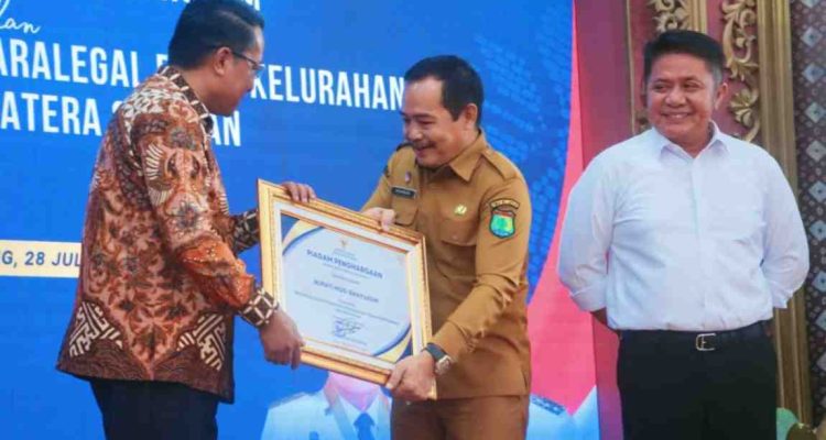 Menteri Hukum RI, Dr Supratman Andi Agtas, SH, MH menyerahkan piagam penghargaan kepada Wabup Muba, Rohman di Griya Agung, Palembang, Senin (28/7/2025). Foto: Kominfo Muba.