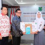 Bupati Muba, HM Toha secvara simbolis menyerahjkan beasiswa Program Edukasi untuk Anak Negeri (PRESTASI) yang diselenggarakan oleh PT Baturona Adimulya dan PT Astaka Dodol, Jumat (31/7/2025). Foto: Kominfo Muba.