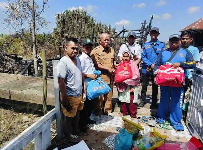 Dua warga pemilik rumah di Desa Karang Agung (Sungai Kubu), Kecamatan Lalan, Kabupaten Musi Banyuasin yang terbakar, Senin (21/7/2025) menmerima bantuan dari Pemkab Muba. Foto: Dok Kecamatan Lalan.
