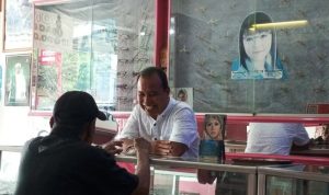 Uda Andi, Owner Optik Sriwijaya, sedang melayani pelanggan yang datang untuk membeli kacamata. (SUMSELHEADLINE.COM/OYONG)