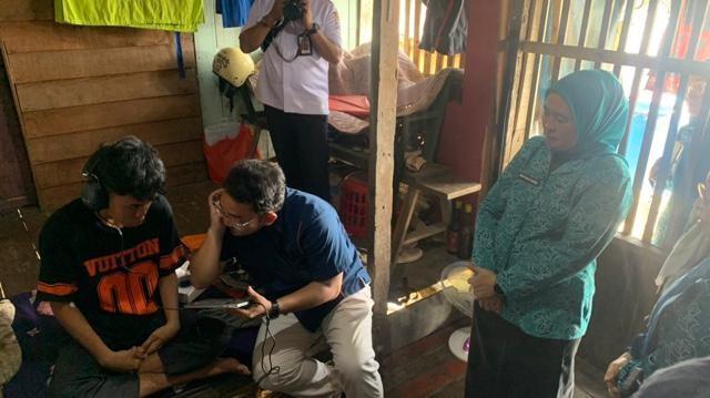 Warga Jakabaring mencoba alat bantu dengar yang diberikan Ketua TP PKK Palembang, Rabu (27/8/2025). Foto: Kominfo Palembang.