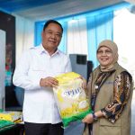 Wagub Sumsel, Cik Ujang secara simbolis menyerahkan beras pada kegiatan gerakan pangan murah yang dgelar Polda Sumsel dan Bulog di Seberang Ulu, Palembang. Foto: Humas Pemprov Sumsel.