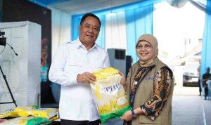 Wagub Sumsel, Cik Ujang secara simbolis menyerahkan beras pada kegiatan gerakan pangan murah yang dgelar Polda Sumsel dan Bulog di Seberang Ulu, Palembang. Foto: Humas Pemprov Sumsel.