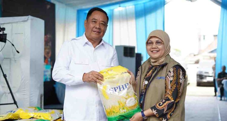 Wagub Sumsel, Cik Ujang secara simbolis menyerahkan beras pada kegiatan gerakan pangan murah yang dgelar Polda Sumsel dan Bulog di Seberang Ulu, Palembang. Foto: Humas Pemprov Sumsel.