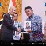 Chairul S Matdiah menyerahkan buku biografi kepada Gubernur Sumsel Herman Deru pada acara launching di Ballroom Hotel Aryaduta Palembang, Sabtu (23/8/2025). Foto: IST