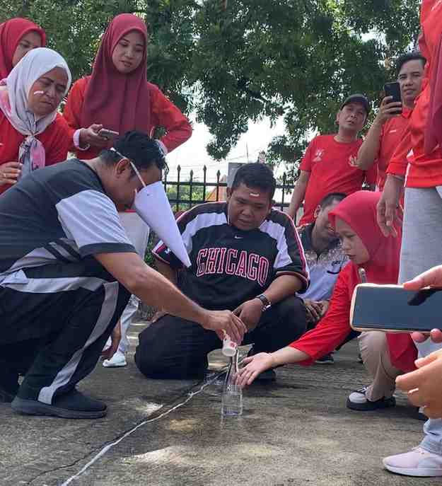 Suasana lomba memasukkan air dalam botol di lingkungan Dinas Tenaaga Kerja dan Transmigrasi Muba. Foto: Kominfo Muba.
