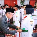 Walikota Palembang, Ratu Dewa memasang sabuk anggota Paskibraka, Jumat (15/8/2025) malam. Foto: Kominfo Palembang.