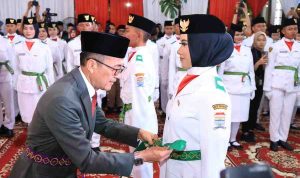 Walikota Palembang, Ratu Dewa memasang sabuk anggota Paskibraka, Jumat (15/8/2025) malam. Foto: Kominfo Palembang.
