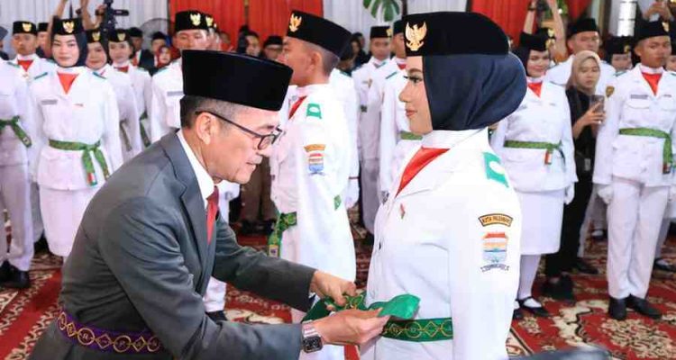 Walikota Palembang, Ratu Dewa memasang sabuk anggota Paskibraka, Jumat (15/8/2025) malam. Foto: Kominfo Palembang.