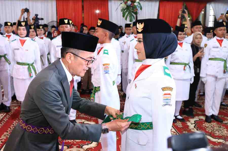 Walikota Palembang, Ratu Dewa memasang sabuk anggota Paskibraka, Jumat (15/8/2025) malam. Foto: Kominfo Palembang.